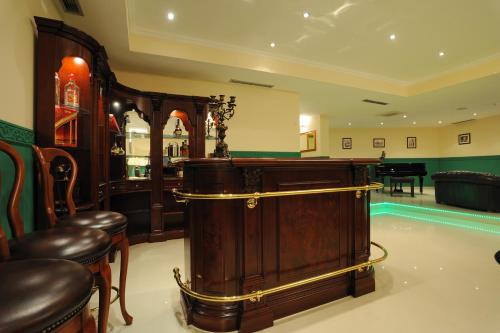 un bar con un armario de madera y taburetes en una habitación en Hotel Solitudo en Ubli