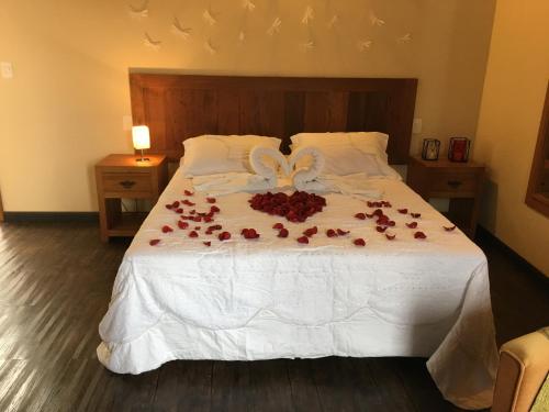 a bedroom with a bed with roses on it at Pousada Vivendas Da Serra in Catas Altas