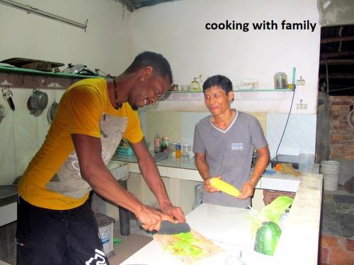 two men standing in a kitchen preparing food at mekong floating market Nam Giang homestay in Cai Be