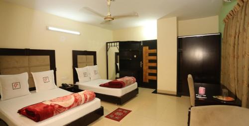 pokój z 2 łóżkami i krzesłem w obiekcie Grand Beach Resort w mieście Koks Badźar