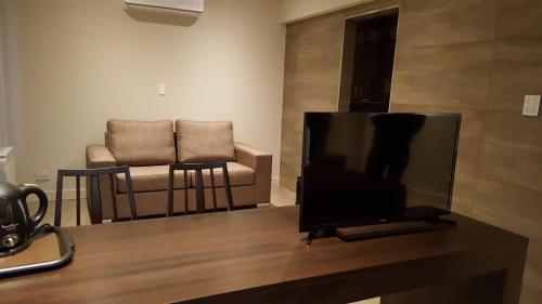 a flat screen tv sitting on a table with a chair at Hotel Riogrande in Santa Fe