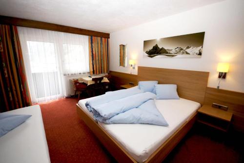 イシュグルにあるGarni Rudigierのベッドとデスクが備わるホテルルームです。