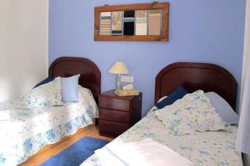 a bedroom with two beds and a mirror on the wall at Cal Mosqueta in Sant Llorenc de Morunys