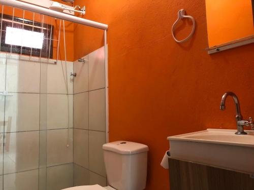 y baño con aseo, ducha y lavamanos. en Pousada Residencial Família Dragone, en Bombinhas