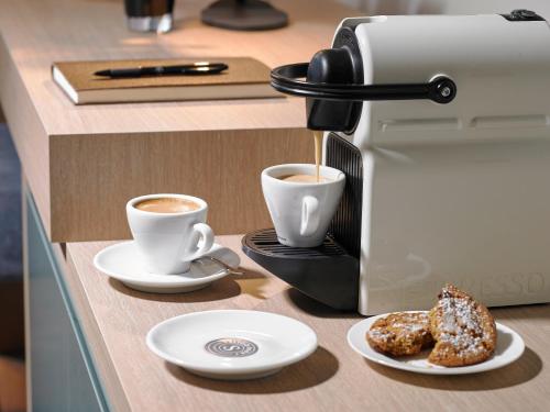 a coffee machine and two cups of coffee on a counter at Sligo Park Hotel & Leisure Club in Sligo