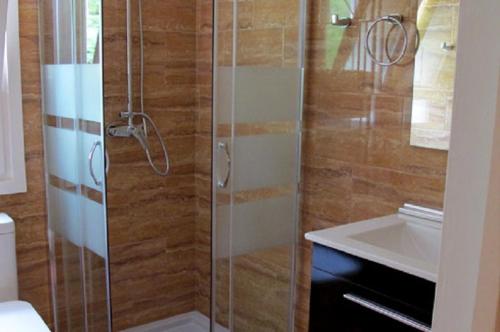 a bathroom with a glass shower with a sink at Cal Mosqueta in Sant Llorenc de Morunys