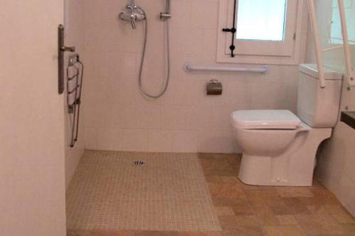 a bathroom with a shower with a toilet and a window at Cal Mosqueta in Sant Llorenc de Morunys