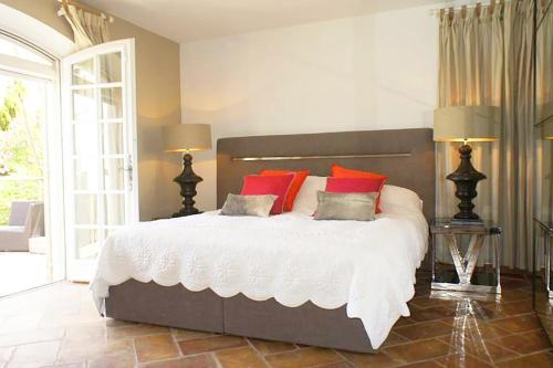 une chambre avec un grand lit avec des oreillers rouges dans l'établissement Villa Zara - Saint Tropez Holiday Villa, à Saint-Tropez