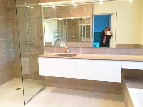 une femme prenant une photo d'une salle de bains avec lavabo dans l'établissement Villa Zara - Saint Tropez Holiday Villa, à Saint-Tropez