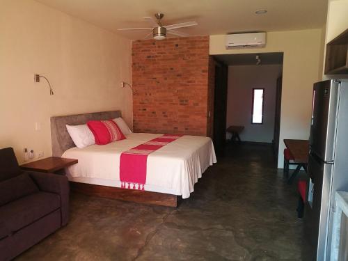 a bedroom with a bed and a brick wall at Casa de la Ballena in Sayulita