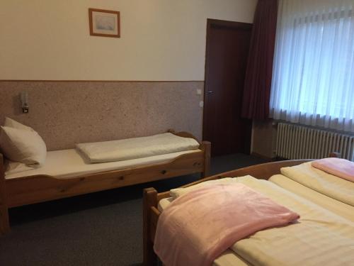 a hotel room with two beds and a window at Gästehaus Wagner in Grainau