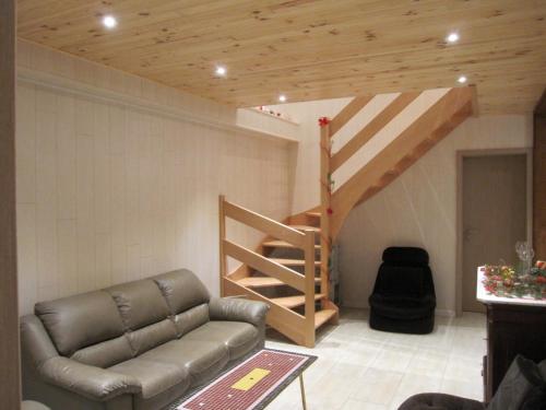 a living room with a couch and a staircase at Le Relais de la Houille in Sart-Custinne