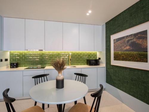 a kitchen with a white table and chairs at Apartamentos The Arc Carrís in Porto