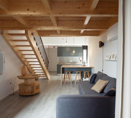 a living room with a blue couch and a kitchen at 7 Gaia Roaster Apartments in Vila Nova de Gaia