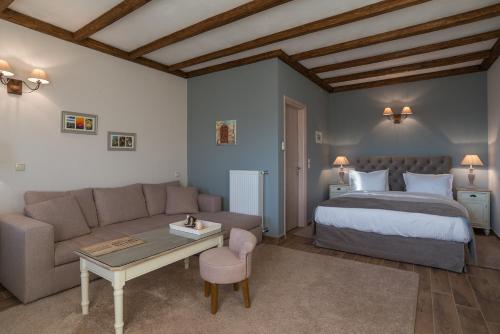 a bedroom with a bed and a couch and a table at AlmondHouse Suites with Fireplace - ADULTS ONLY in Arachova