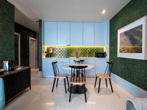 a kitchen with a table and chairs in a room at Apartamentos The Arc Carrís in Porto