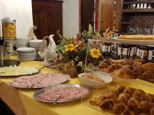 a table topped with different types of food and bread at Hotel Martin in Sauze dʼOulx