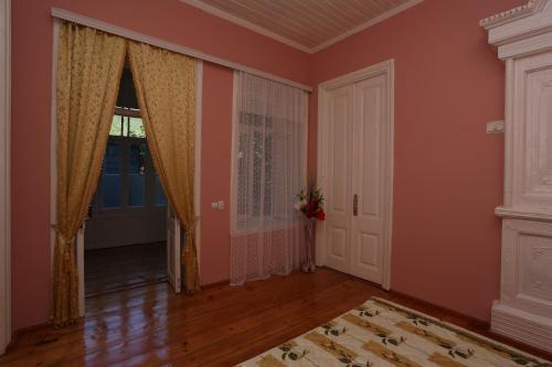 an empty room with orange walls and a door at Ilham Mustafa Houses in Sheki