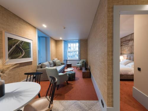 a hotel room with a king bed and a living room at Apartamentos The Arc Carrís in Porto