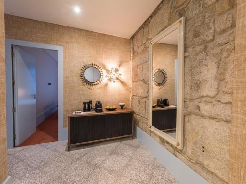 a hallway with a stone wall and a mirror at Apartamentos The Arc Carrís in Porto