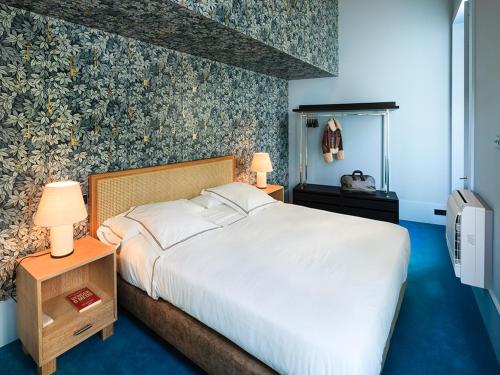 a bedroom with a large white bed with blue carpet at Apartamentos The Arc Carrís in Porto