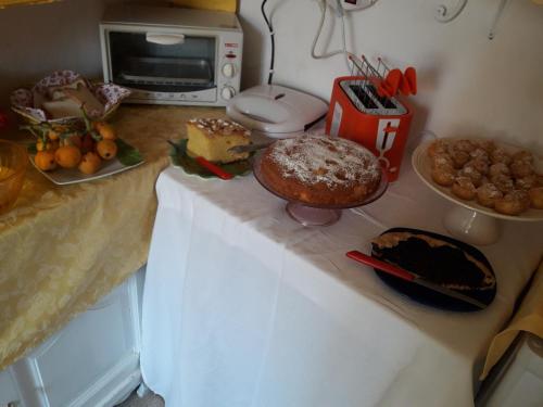 a counter top with cakes and other foods on it at Da Giusè in Trebiano