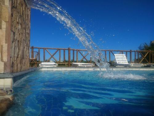 a water fountain in a swimming pool at Pousada Ilha do Meio in Itacimirim