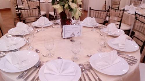 a table with white plates and forks and napkins at Excelaris Grand Resort Conventions & Spa in Tequesquitengo
