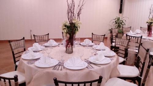 a long table with white tablecloths and napkins at Excelaris Grand Resort Conventions & Spa in Tequesquitengo