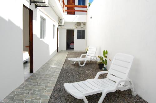 two white chairs sitting in a corridor of a building at Hotel Castelo La Paloma in Gamboa