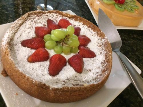 a cake with strawberries and powdered sugar on a plate at Excelaris Grand Resort Conventions & Spa in Tequesquitengo