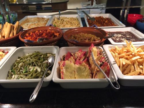 a buffet with many trays of food on a table at Excelaris Grand Resort Conventions & Spa in Tequesquitengo