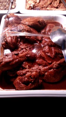 a styrofoam container of meat with a spoon and sauce at Excelaris Grand Resort Conventions & Spa in Tequesquitengo