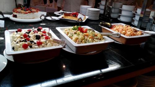 a buffet with three trays of food on a counter at Excelaris Grand Resort Conventions & Spa in Tequesquitengo