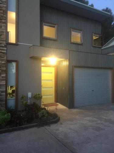a house with a yellow door and a garage at Tangles in Ballarat