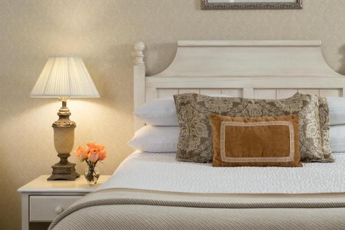 a bedroom with a white bed with a lamp and pillows at Linden Row Inn in Richmond