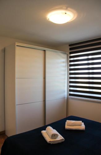 a bedroom with a bed with two towels on it at Apartmani Marin in Vrbnik