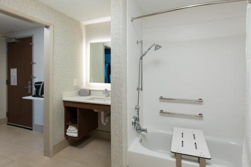 a bathroom with a bath tub and a sink at Holiday Inn Express Visalia-Sequoia Gateway Area, an IHG Hotel in Visalia