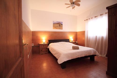 MONTAÑA VALLES DE ORTEGA - A في Valles de Ortega: غرفة نوم بسرير ومروحة سقف