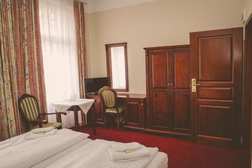 a hotel room with two beds and a desk at Hotel Willa Starosty in Międzyrzecz
