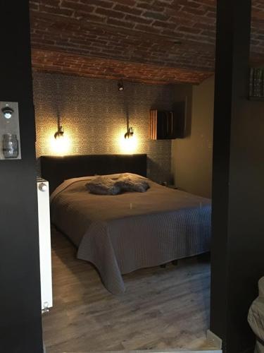 a bedroom with a bed in a room with lights at Gîte de Corbion loft2 in Ciney