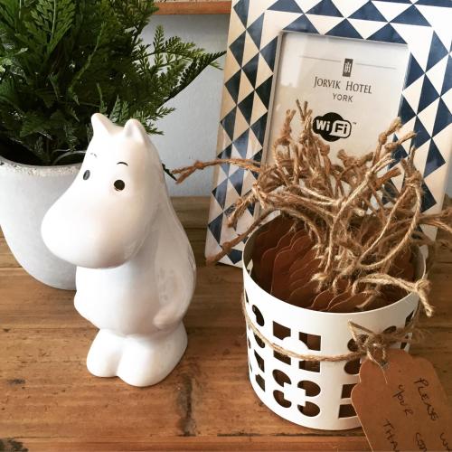 a white cat figurine next to a basket of roots at Jorvik House in York