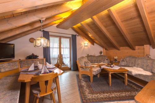 ein Wohnzimmer mit einem Sofa und einem Tisch in der Unterkunft Ferienhäuser Werdenfels in Mittenwald