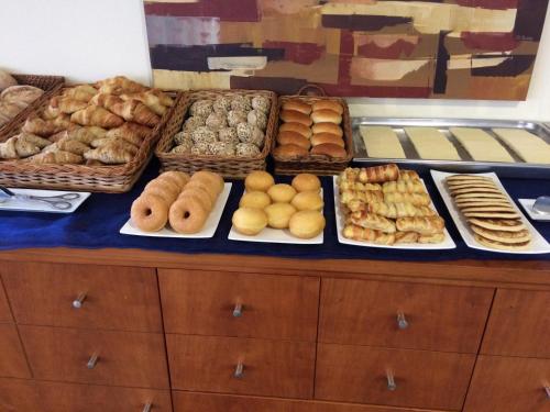 a table topped with lots of different types of pastries at Hotel Pombeira in Guarda