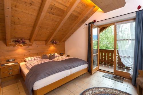 a bedroom with a bed and a large window at Ferienhäuser Werdenfels in Mittenwald