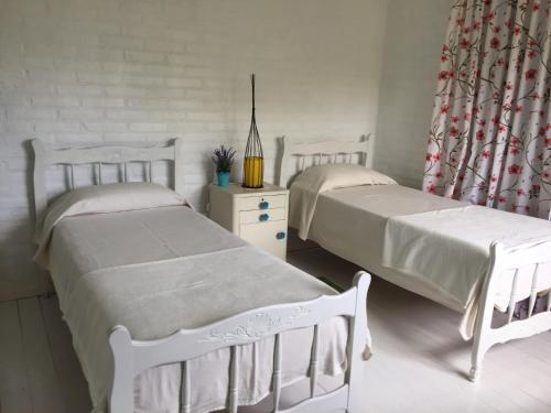 a bedroom with two beds and a window at Raco De La Calma in Nono