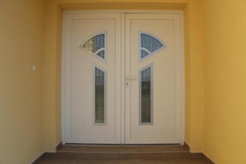 Una puerta blanca con 2 ventanas en una habitación en Apartmani Marin en Vrbnik