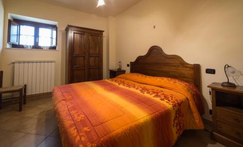 a bedroom with a large bed with an orange blanket at Residenza Il Falchetto in Assisi