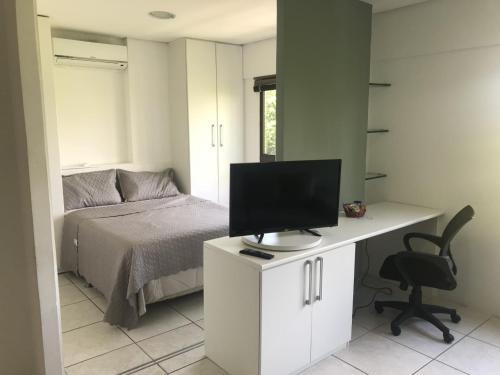 a bedroom with a bed and a desk with a computer at Flat Gildo Vilaça in Recife