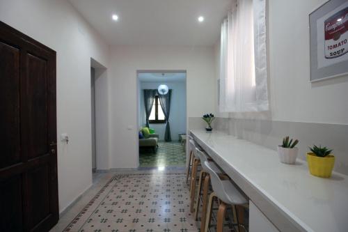 una cucina con un lungo bancone con sgabelli di De Nobili's Apartments a Trapani